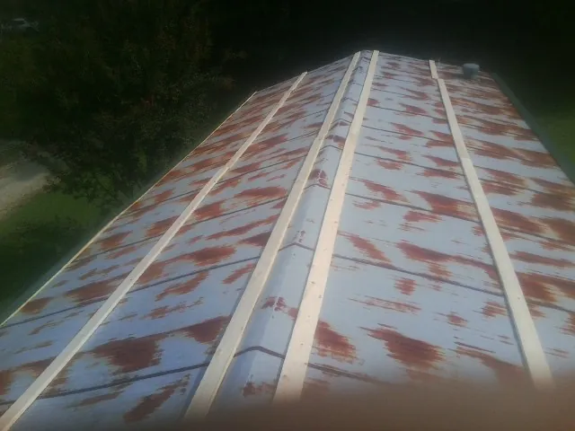 Rusted metal roof panels with new wood purlins before replacement — Storm Damage Roof Repair in Wittman by Roofing Brothers