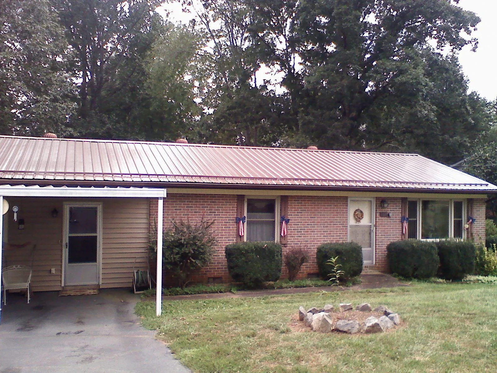 Bronze metal roof and carport on a brick ranch home — Roof Repair work by our crew in Wittman
