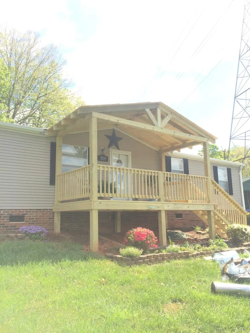 New gabled porch roof and deck railing added to a ranch home in Wittman